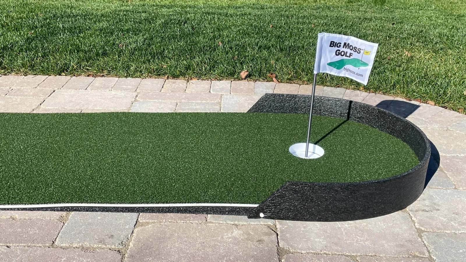 Big Moss Commander putting green with a flag on a patio