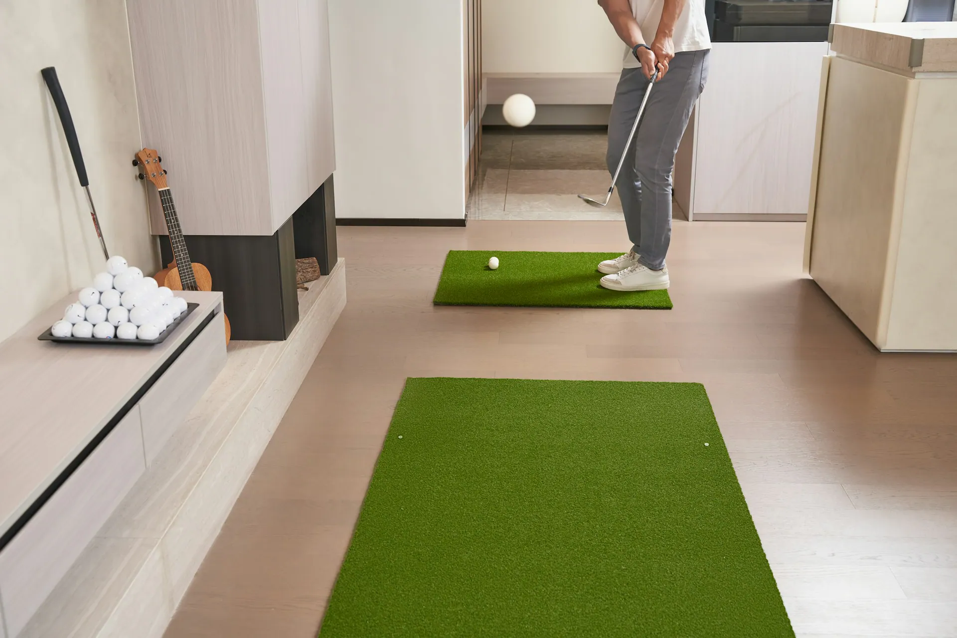 Golfer practicing on mats in a living room