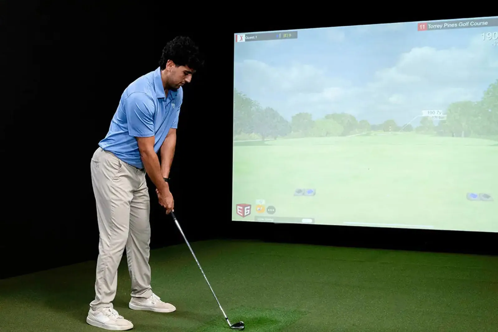 Golfer in an indoor simulator with a FlightScope Mevo Gen2 behind the ball