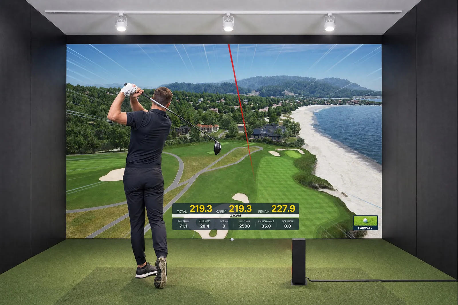 Golfer in a simulator bay with a Uneekor EYE MINI LITE beside the hitting mat